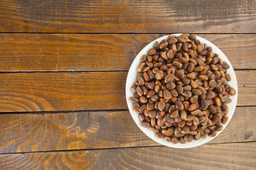 pine nuts and pine cone on wooden table