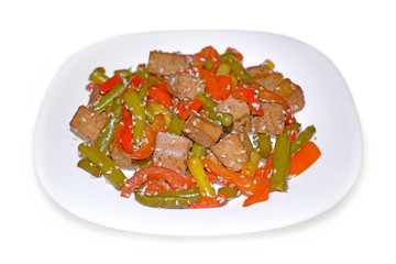 Asian salad with roasted tofu, paprika and green beans on white plate isolated on white background.