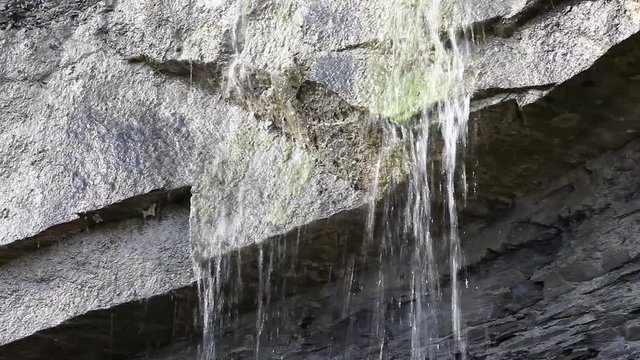 water falling on the rocks during the winter on a sunny day on the Italian Apennines mountains