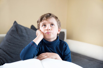 young boy child think during homework want find answer