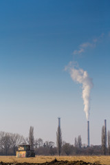 Air pollution by smoke coming out of factory chimney