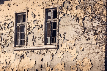 Old Peeling Yellow Wall with Two Windows without Glass