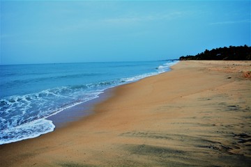 A coastal view, showing a still picturesque scene, of waves washing in and out.