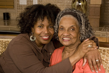 Portrait of a senior woman hugging her daughter.