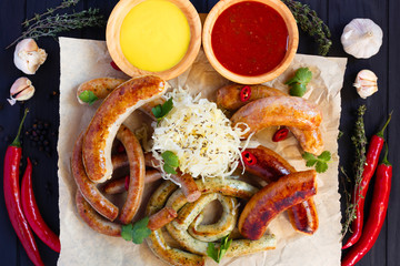  Sausage assortment served with red and yellow sauces, pickled cabbage, herbs and spices