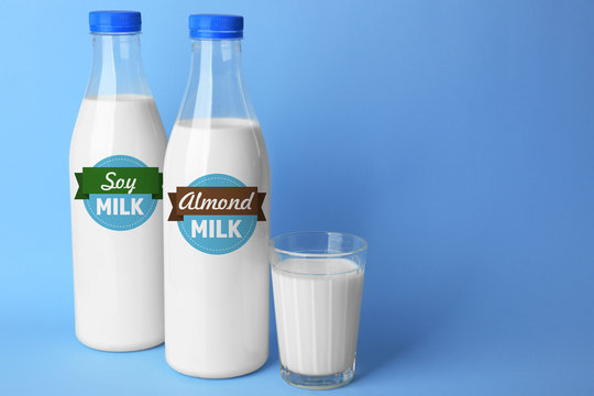Bottles of tasty milk with glass on blue background