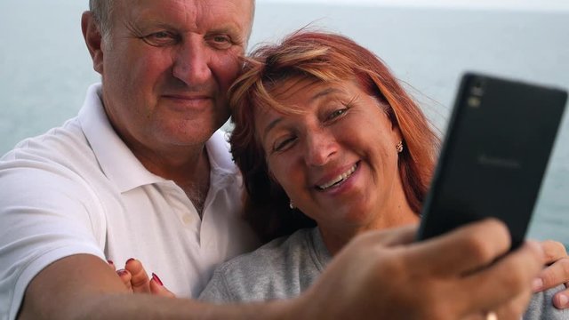 Middle-Aged Couple Taking Selfie with Mobile Phone at Sea
