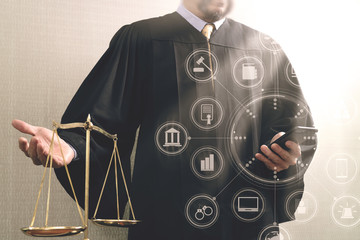 justice and law concept.Male judge in a courtroom with the balance scale and using smart phone