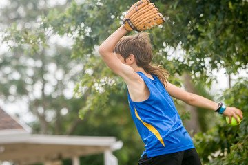 young preteen boy playing softball on outdoor background