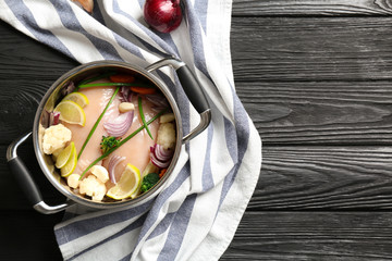 Raw chicken breasts with lemon and vegetables in saucepan
