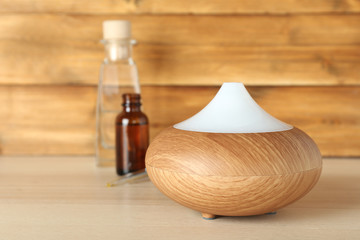 Aroma oil diffuser on wooden background