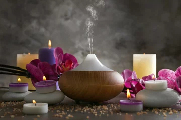 Fotobehang Aroma oil diffuser, candles and flowers on table © Africa Studio