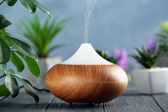 Aroma oil diffuser on wooden table
