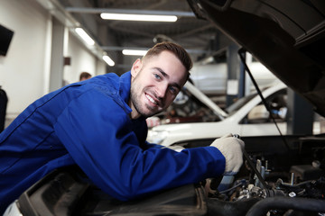 Mechanic repairing car with open hood