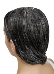 Naklejka premium Young woman with coconut oil applied onto hair, on white background