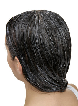 Young woman with coconut oil applied onto hair, on white background