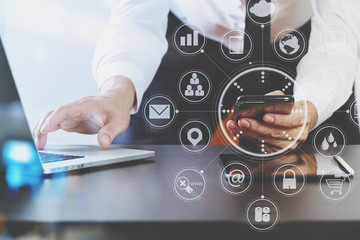 close up of businessman working with smart phone and laptop and digital tablet computer in modern office
