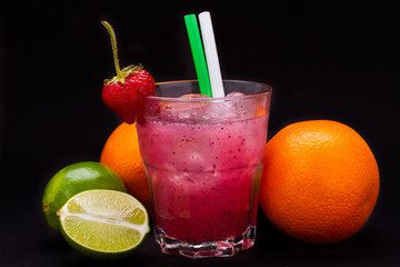 strawberry cocktail in glass with straw on black background