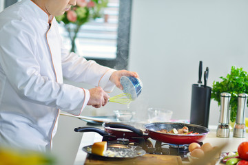 mature chef preparing a meal with various vegetables and meat