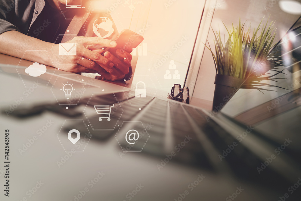 Poster businessman working with smart phone and laptop computer on wooden desk in modern office with virtual icons interface