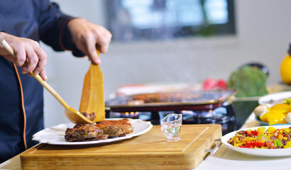 mature chef preparing a meal with various vegetables and meat