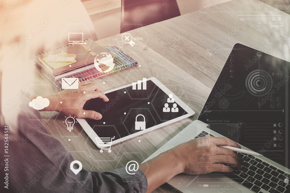 Poster businessman working with laptop computer and digital tablet and book and document on wooden desk in modern office with virtual icons interface