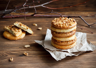 Homemade cookies with a peanut on paper for pastries on wooden table. Selective focus.