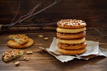 Homemade cookies with a peanut on paper for pastries on wooden table. Selective focus.