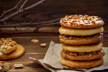 Cookies with a peanut on paper for pastries on wooden table. Selective focus, closeup.