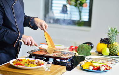 mature chef preparing a meal with various vegetables and meat