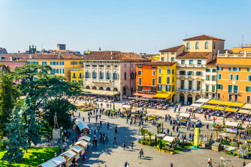 People are strolling among flower stands during Saturday market on the piazza bra in the Italian...