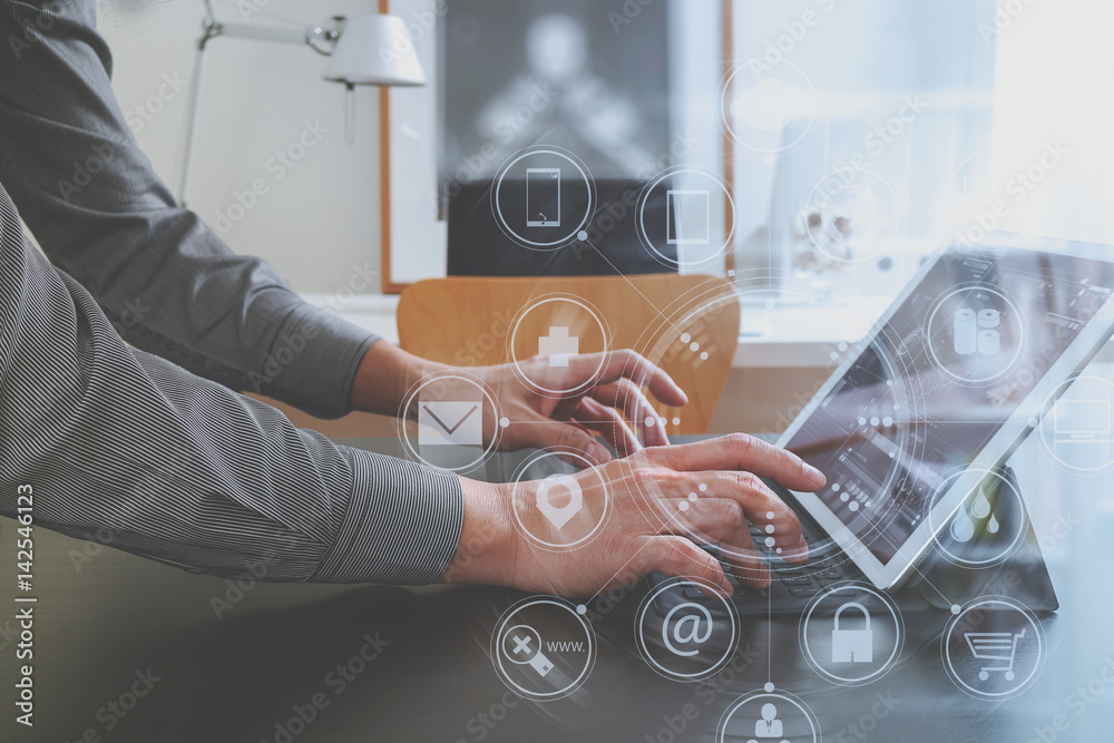 Poster businessman or Designer using digital tablet computer on black desk in modern office with virtual interface graphic icons network diagram
