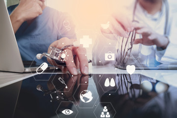 Medical co working concept,Doctor working with smart phone and digital tablet and laptop computer to meeting his team in modern office at hospital with virtual diagram
