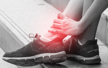 sport injury concept, woman suffering from an ankle injury while exercising and running.