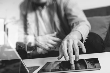 hipster hand using smart phone,digital tablet docking keyboard,coffee cup, payments online business,sitting on sofa in living room,work at home concept