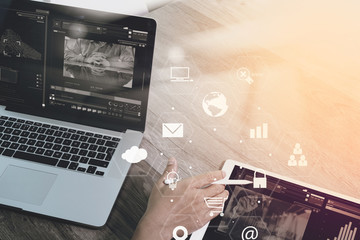 businessman working with smart phone and laptop computer on wooden desk in modern office with virtual icons interface