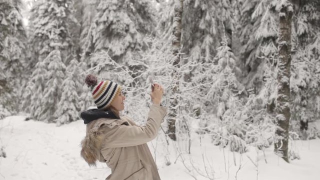 Girl Taking Pictures on the Phone Winter Forest