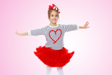 Little girl in a red skirt and bow on her head.