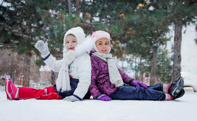 Cute girls having fun among winter park