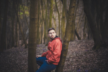 Trendy handsome man posing in spring park alone