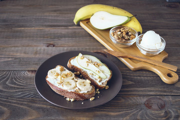Sandwiches of rye bread and ripe fruit pear banana Apple served on a plate