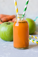 Fresh from apples and carrots in a glass bottle