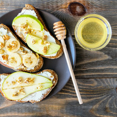Sandwiches of rye bread and ripe fruit pear banana Apple served on a plate