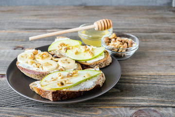 Sandwiches of rye bread and ripe fruit pear banana Apple served on a plate