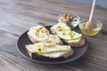 Sandwiches of rye bread and ripe fruit pear banana Apple served on a plate