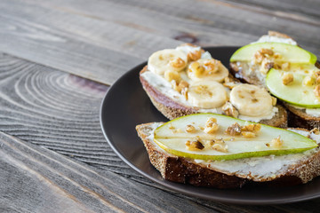 Sandwiches of rye bread and ripe fruit pear banana served on a plate
