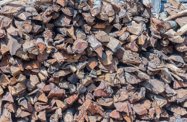 Abstract background of stored pieces of small wood ready for heating, chopped at home in the countryside.