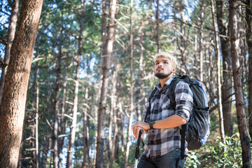 Naklejka na ściany i meble Young Man Traveler with backpack relaxing outdoor with pine forest mountains on background, Hike concept.