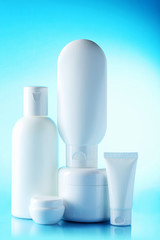 White cosmetic bottles on a blue background