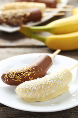 Banana covered in chocolate on a grey wooden table
